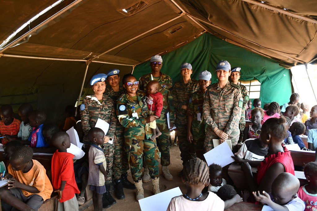 La Commandante d’escadron Sharon Syme, originaire du Ghana (tenant un jeune garçon dans ses bras), a été nommée Défenseure militaire de l’égalité des sexes de l’ONU pour l’année 2024.